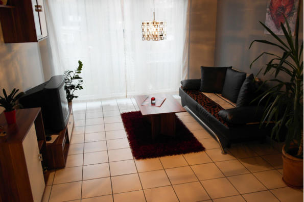 Wohnzimmer mit franzsischem Balkon. Genieen Sie den Ausblick ber die Grten von Waghusel. Ausziehsofa, Tisch und TV.