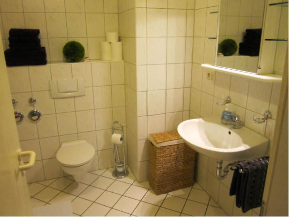 Badewanne, Dusche, Waschbecken und WC sowie einen Spielgelschrank. Duschabtrennung mit Schiebetren.