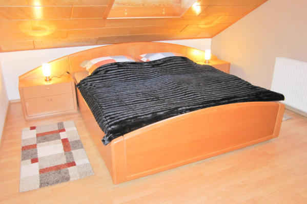 Legen Sie sich auf dad Doppelbett und genieen Sie den Ausblick durch das Dachfenster mit Rollladen.